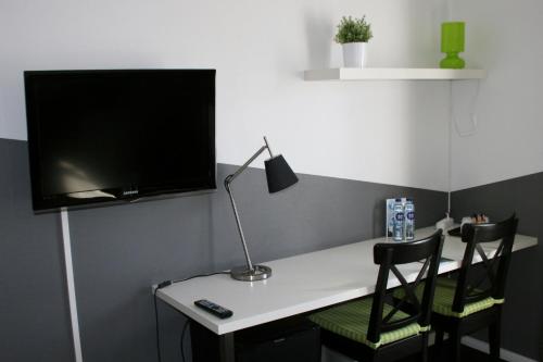 a desk with two chairs and a tv on a wall at Taastrup Park Hotel in Tåstrup