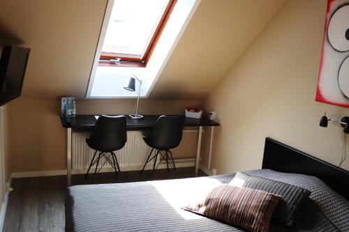 a bedroom with a bed and a desk under a skylight at Taastrup Park Hotel in Tåstrup