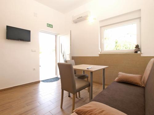 a room with a bed and a table and a window at Apartments Biljana 1480 in Ližnjan