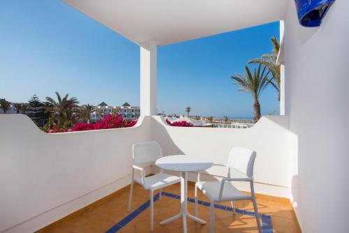 a table and chairs in a balcony with a view of the ocean at Iberostar Waves Founty Beach All Inclusive in Agadir