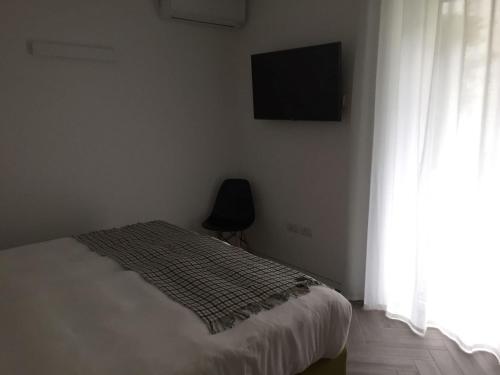 a bedroom with a bed and a television and a window at Hotel Garnì Villa Maria in Riva del Garda