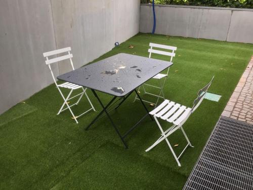 a table and four chairs on a grass field at Hotel Garnì Villa Maria in Riva del Garda