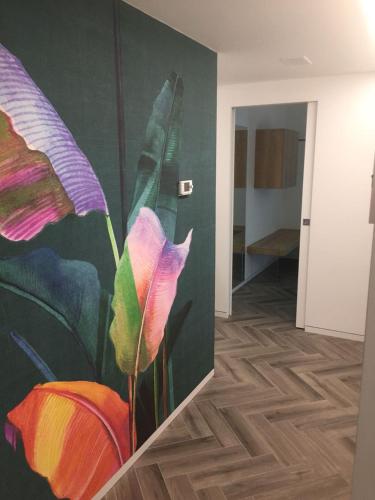 a painting of a flower on a wall in a room at Hotel Garnì Villa Maria in Riva del Garda