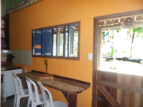 a kitchen with a table and chairs and a window at Casinhas Vila Bonita Amarela in Baía Formosa
