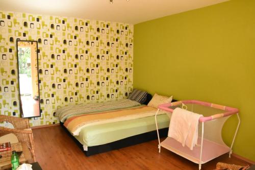 een slaapkamer met een bed in een kamer met groene muren bij Lovely apartment at Balatonfenyves in Balatonfenyves