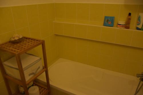 バラトンフェニヴェシュにあるLovely apartment at Balatonfenyvesの黄色のバスルーム(バスタブ、棚付)