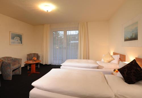 a hotel room with two beds and a window at Air Hotel Wartburg in Düsseldorf