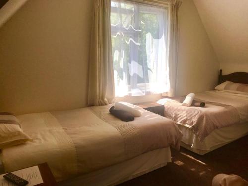 two beds in a room with a window at Landguard House Bed Only in Southampton
