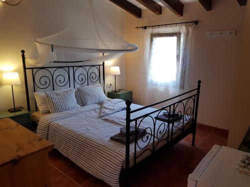 um quarto com uma cama grande e um dossel branco em Finca Caballo Blanco em Montuiri