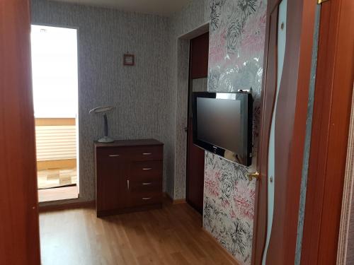 ウシンスクにあるАппартаменты на Ленина, 15の壁にテレビが付いた部屋