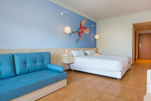 a bedroom with a bed and a couch at Iberostar Waves Founty Beach All Inclusive in Agadir