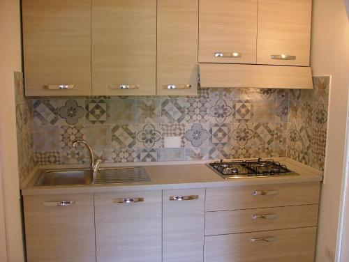 a kitchen with wooden cabinets and a sink at Villa Maria Carla in Capoliveri