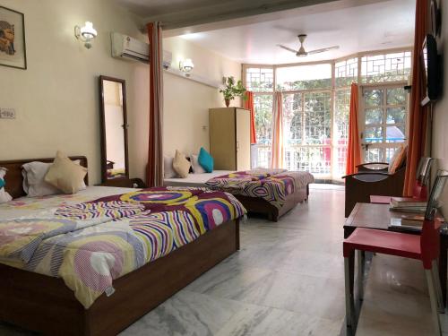 a bedroom with two beds and a table and a room at Sailors Home - C6, Vasant Kunj in New Delhi