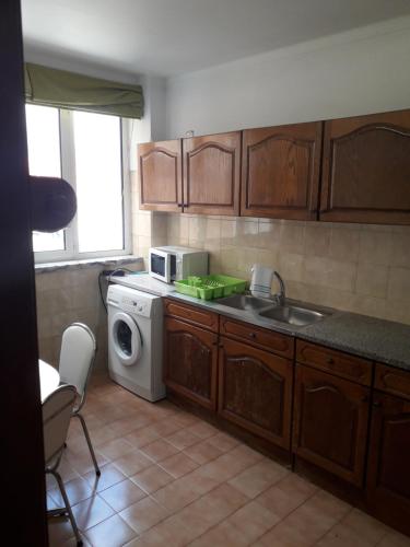 cocina con fregadero y lavadora en Apartamento 300 metros do SANTUÁRIO DE FÁTIMA T4, en Fátima
