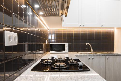 a kitchen with a stove and a microwave at Casa do Tanque T2 in Arouca