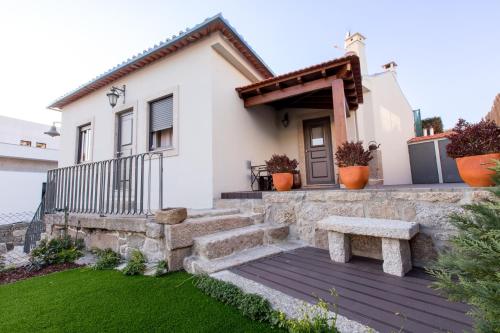 a white house with a bench in front of it at Casa do Tanque T2 in Arouca
