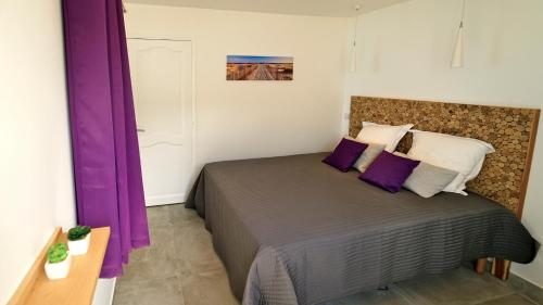 - une chambre avec un grand lit et des rideaux violets dans l'établissement Grand Case Beach, à Grand-Case