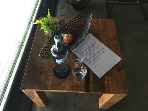 a table with a bottle of water and a glass at Boutique Hotel Chalet Weinberg in Würgau