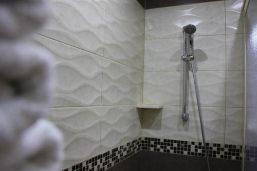 a shower in a bathroom with black and white tiles at Lamedina Hotel & Resort in Jounieh