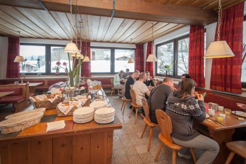 un groupe de personnes assises à une table dans un restaurant dans l'établissement Bed & Breakfast Der Tiroler, à Achenkirch