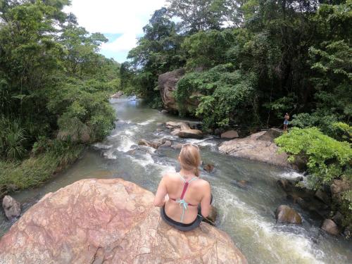 a woman in a bikini sitting on a rock in a river at La Pentera in Hambegamuwa