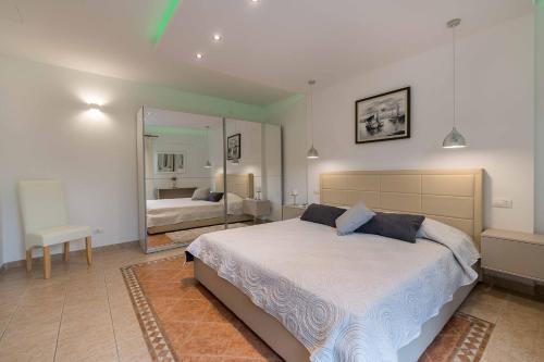 1 dormitorio con 1 cama grande y espejo en Apartments Villa Tre Marie, en Rovinj