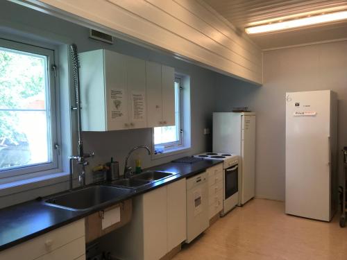 una cocina con fregadero y refrigerador en Fosseland Gjestegård, en Feda