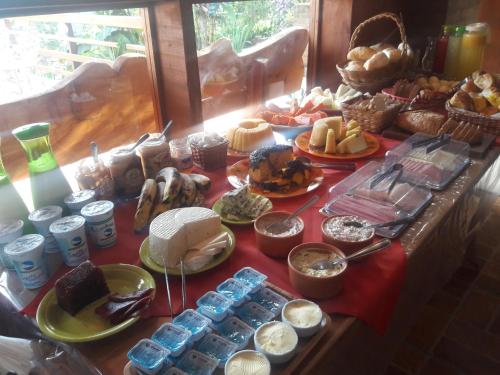 a table topped with lots of different types of food at Pousada Pinhalense in Santo Antônio do Pinhal