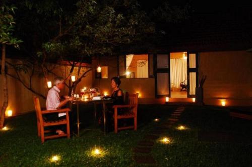 a man and a woman sitting at a table at night at Green Herbal Ayurvedic Eco-Lodge in Galle