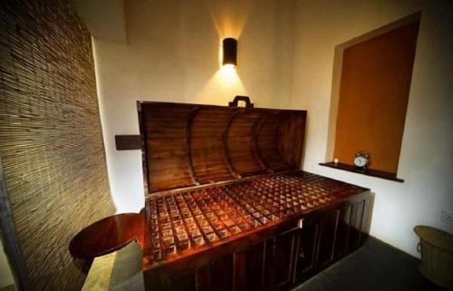 a wooden bed in a room with a light on it at Green Herbal Ayurvedic Eco-Lodge in Galle