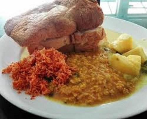 a white plate of food with bread and other foods at Green Herbal Ayurvedic Eco-Lodge in Galle