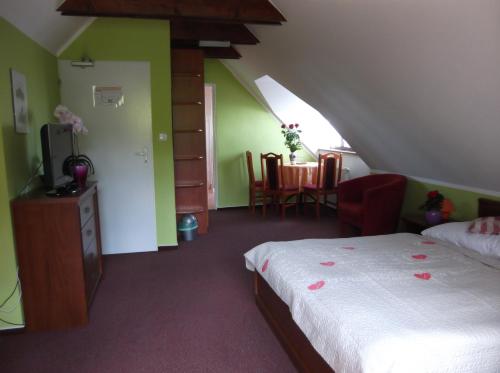 a bedroom with a bed and a table and chairs at Penzion Lesna in Vysoké Tatry