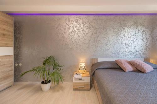 a bedroom with a bed and a potted plant at Apartments Villa Tre Marie in Rovinj