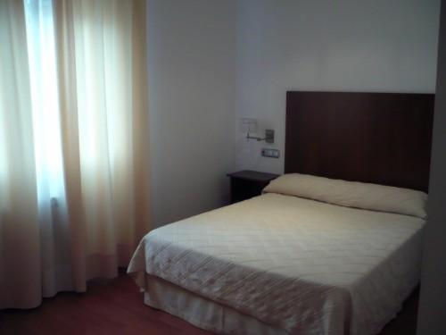 a bedroom with a white bed and a window at Valcarce Urbasa in Olazagutía