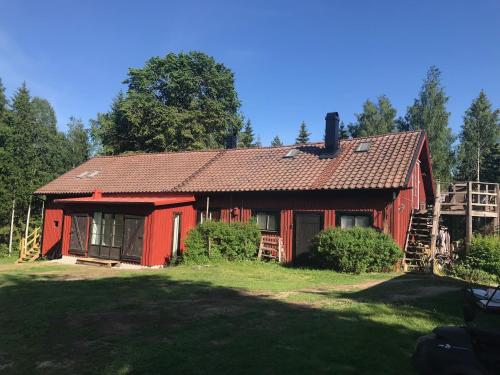 カトリーネホルムにあるBjörnåsen Bear Hillの緑豊かな庭の上に座る赤い家