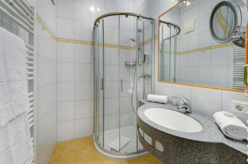 a bathroom with a sink and a shower at VÖTTER'S HOTEL in Kaprun - summer card included in Kaprun