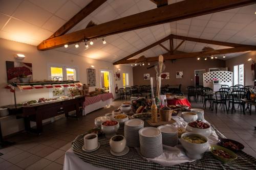 a table with plates and bowls of food on it at Village Vacances Passion L'Emeraude in Damvix