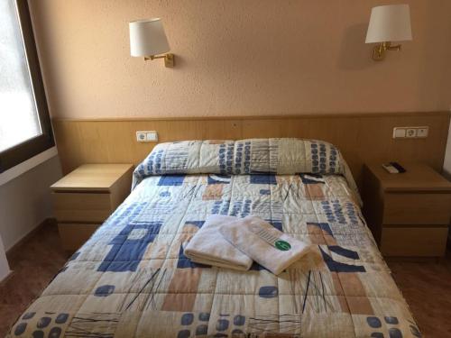 a bedroom with a bed with towels on it at Hostal Rio De Castro in Barcelona