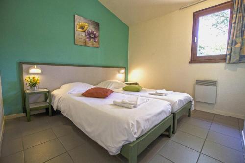 sypialnia z łóżkiem z białą pościelą i oknem w obiekcie Village Vacances Passion L'Emeraude w mieście Damvix