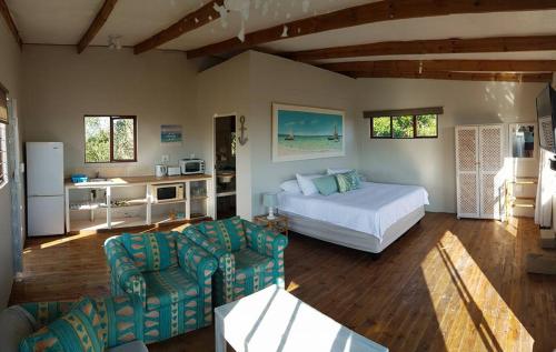 1 dormitorio con 1 cama y sala de estar en Dune View Cottage, en Sodwana Bay