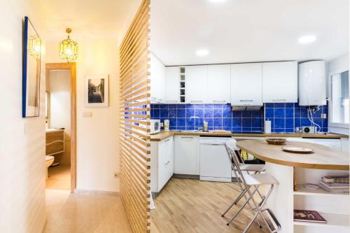 a kitchen with white cabinets and a wooden table at Apartamento Paseo del Salón in Granada