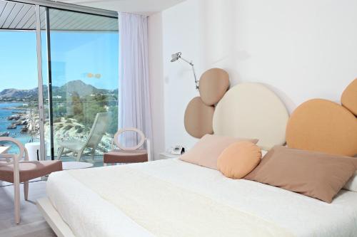 a bedroom with a bed with a view of the ocean at Son Moll Sentits Hotel & Spa - Adults Only in Cala Ratjada