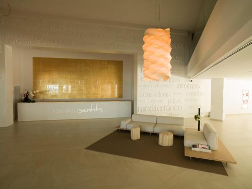 a lobby with a couch and a wall with writing on it at Son Moll Sentits Hotel & Spa in Cala Ratjada