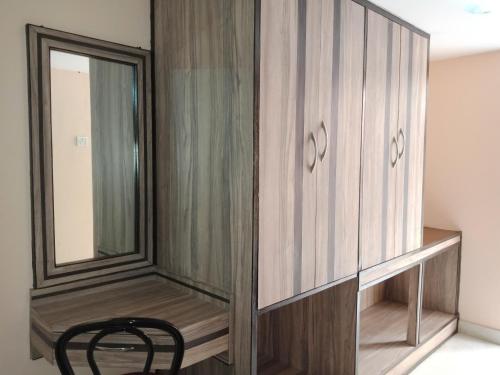 a dressing room with a wooden cabinet and a black chair at Hotel Shikhar & Restaurant in Almora