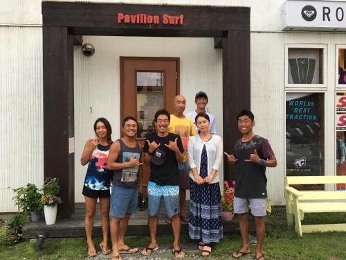 a group of people standing in front of a building at PavilionSurf&Lodge in Shishikui