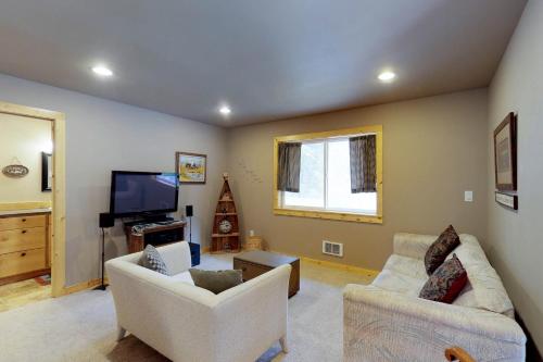 a living room with two chairs and a flat screen tv at Peaceful Pines in Plain