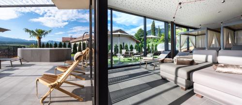 a living room with a couch and chairs on a balcony at Hotel Christof in Appiano sulla Strada del Vino