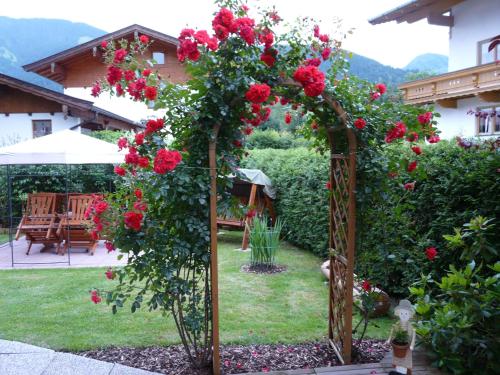 an arch with roses on it in a garden at Ferienwohnung Huber in Söll
