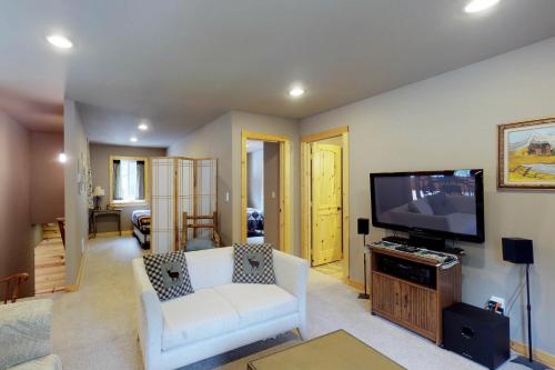 a living room with a flat screen tv and a couch at Peaceful Pines in Plain