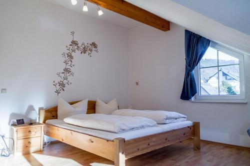 1 dormitorio con cama de madera y ventana en Ferienwohnungen Scheid Volker, en Sankt Aldegund